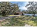 Front view of a red brick home with a spacious yard at 150 Sage Rd, Crystal Beach, FL 34681