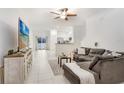 Open-concept living room with sectional sofa, large TV, and view of kitchen at 36401 Camp Fire Ter, Zephyrhills, FL 33541