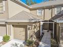 Tan two-story townhome with attached garage and walkway at 4207 Key Thatch Dr, Tampa, FL 33610