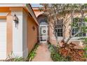 Front entrance with a screen door, brick pathway, and lush landscaping at 4936 Sandy Brook Cir, Wimauma, FL 33598