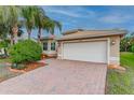House exterior featuring a white garage door and brick paver driveway at 5004 Sandy Brook Cir, Wimauma, FL 33598