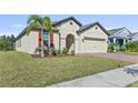 Tan house with red shutters and paver driveway at 6032 Milestone Dr, Apollo Beach, FL 33572