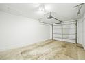 An empty one-car garage featuring a white wall, an automatic door opener, and a metal door at 6543 Barcelona Blvd, Brooksville, FL 34602