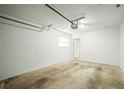 An empty one-car garage featuring a textured wall, single window, and utility door to the home's interior at 6543 Barcelona Blvd, Brooksville, FL 34602