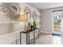 Bright entryway with striped walls, decorative mirrors, and a console table at 10558 Dusty Boot Rd, Land O Lakes, FL 34638