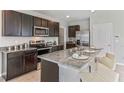 Modern kitchen with dark wood cabinets, granite countertops, and stainless steel appliances at 10558 Dusty Boot Rd, Land O Lakes, FL 34638