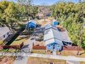 Aerial view of blue house, sheds and fenced yard at 14045 21St St, Dade City, FL 33525