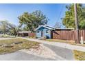 Blue house with wooden fence and side yard view at 14045 21St St, Dade City, FL 33525