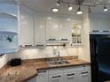 Bright kitchen boasts white cabinets, granite counters, and modern appliances at 1799 N Highland Ave # 44, Clearwater, FL 33755