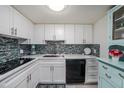 Modern kitchen with white cabinets, updated appliances, and tile backsplash at 2043 Denmark St # 65, Clearwater, FL 33763