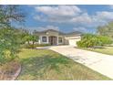 Single-story house with a large driveway and lush green lawn at 3019 124Th E Ave, Parrish, FL 34219