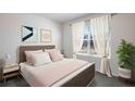 Bedroom with pink bedding, brown headboard, and white sheer curtains at 3040 Living Coral St, Wimauma, FL 33598