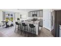 Modern kitchen with gray cabinets, granite counters, and an island at 33182 Osprey Peak Way, San Antonio, FL 33576