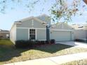 Two-story house with light blue exterior, two-car garage, and landscaping at 504 Magnolia Pointe Ct, Seffner, FL 33584