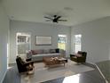 Spacious living room featuring a gray sectional sofa, two armchairs, and a coffee table at 504 Magnolia Pointe Ct, Seffner, FL 33584