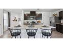 Modern kitchen with dark cabinetry and an island at 5244 Salt Marsh Rd, Wimauma, FL 33598