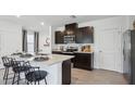 Modern kitchen with dark cabinetry and an island at 5244 Salt Marsh Rd, Wimauma, FL 33598