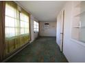Living room with green curtains, tiled floor, and built-in shelving at 801 Woodruff Ave, Clearwater, FL 33756