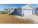 House exterior showcasing a two-car garage and a walkway leading to the front entrance at 10401 Barnett Loop, Port Richey, FL 34668