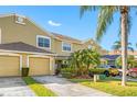 Tan two-story townhome with two-car garage and palm trees at 11246 Kapok Grand Cir, St Petersburg, FL 33708