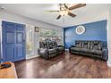 Living room with blue accent wall, hardwood floors, and comfy seating at 11398 88Th Ave, Seminole, FL 33772