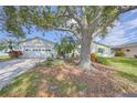 Front view of a white house with mature landscaping and a spacious driveway at 1318 Leland Dr, Sun City Center, FL 33573
