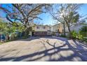 Two-story house with a double garage and a large driveway, surrounded by lush landscaping at 1745 E Mulberry Dr, Tampa, FL 33604