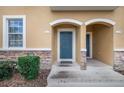 Townhome entrance with gray door and stone accents at 1885 Greenwood Valley Dr, Plant City, FL 33563