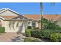 Tan villa with double garage and neatly trimmed hedges at 2315 New Orchard Ct, Sun City Center, FL 33573