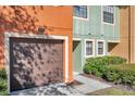 Brown garage door and front door with green and orange siding at 2517 Edgewater Falls Dr, Brandon, FL 33511