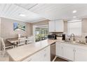 Modern kitchen with white cabinets, stainless steel appliances, and breakfast bar at 3064 Pinetree St, Port Charlotte, FL 33952