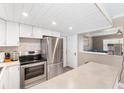 Modern kitchen with white cabinets, stainless steel appliances, and breakfast bar at 3064 Pinetree St, Port Charlotte, FL 33952