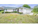 House exterior showcasing landscaping and a two-car garage at 3127 Ivyhill Ct, Holiday, FL 34691