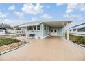 Quaint light blue mobile home with carport and small yard at 37015 Sandra Ave, Zephyrhills, FL 33542