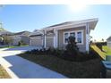 Two-story house with three-car garage, light beige exterior, and landscaping at 6123 Hidden Branch Dr, Apollo Beach, FL 33572