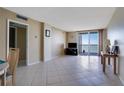 Bright living room with tiled floors, balcony access, and water views at 9 Haig Pl # 707, Dunedin, FL 34698