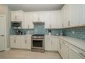 Modern kitchen with white cabinets and light blue tile backsplash at 20108 Sea Glass Cir, Land O Lakes, FL 34638