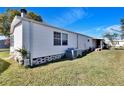 Side view of a manufactured home with AC unit at 3022 Short Leaf St, Wesley Chapel, FL 33543