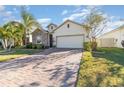 Well-maintained house featuring a brick paver driveway and lush landscaping at 3409 77Th E Ct, Palmetto, FL 34221