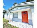 Updated home exterior, featuring a vibrant red door and patterned walkway at 4605 Irene Loop, New Port Richey, FL 34652
