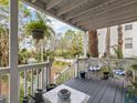 Relaxing front porch with white railings, wicker chairs, and potted plants at 514 Wideview Ave, Tarpon Springs, FL 34689