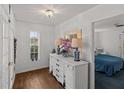 Hallway with hardwood floors, white dresser, and view of bedroom at 514 Wideview Ave, Tarpon Springs, FL 34689