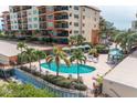 Resort-style pool with ample lounge chairs and patio umbrellas at 5301 Gulf Blvd # E202, St Pete Beach, FL 33706