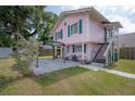 Pink two-story house with green trim, front porch, and pergola at 5901 N Cherokee Ave, Tampa, FL 33604