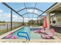 Screened-in pool area with hot tub, lounge chairs, and peaceful waterfront views at 6028 Milestone Dr, Apollo Beach, FL 33572