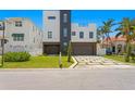Modern home with a three-car garage and landscaped yard at 17059 Dolphin Dr, North Redington Beach, FL 33708