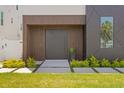 Stylish front entrance with a modern dark brown door and landscaping at 17059 Dolphin Dr, North Redington Beach, FL 33708