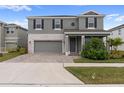 Two-story house with gray siding, stone accents, and landscaping at 18079 Ramble On Way, Land O Lakes, FL 34638