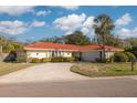 Single story home with red tile roof, driveway, and two-car garage at 2430 Roberta Ln, Clearwater, FL 33764