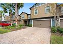 Two-story townhome with a red car parked in the driveway at 28523 Pleasant Bay Loop, Wesley Chapel, FL 33543